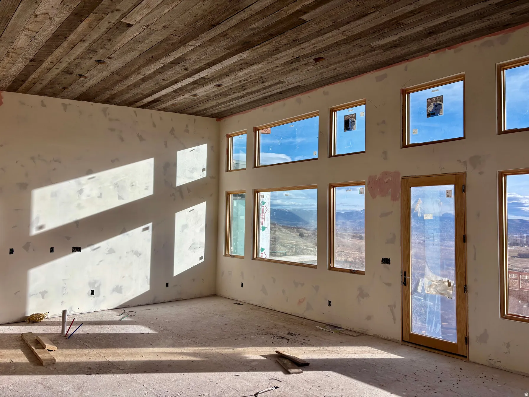 Unfurnished living room with wooden ceiling and a towering ceiling