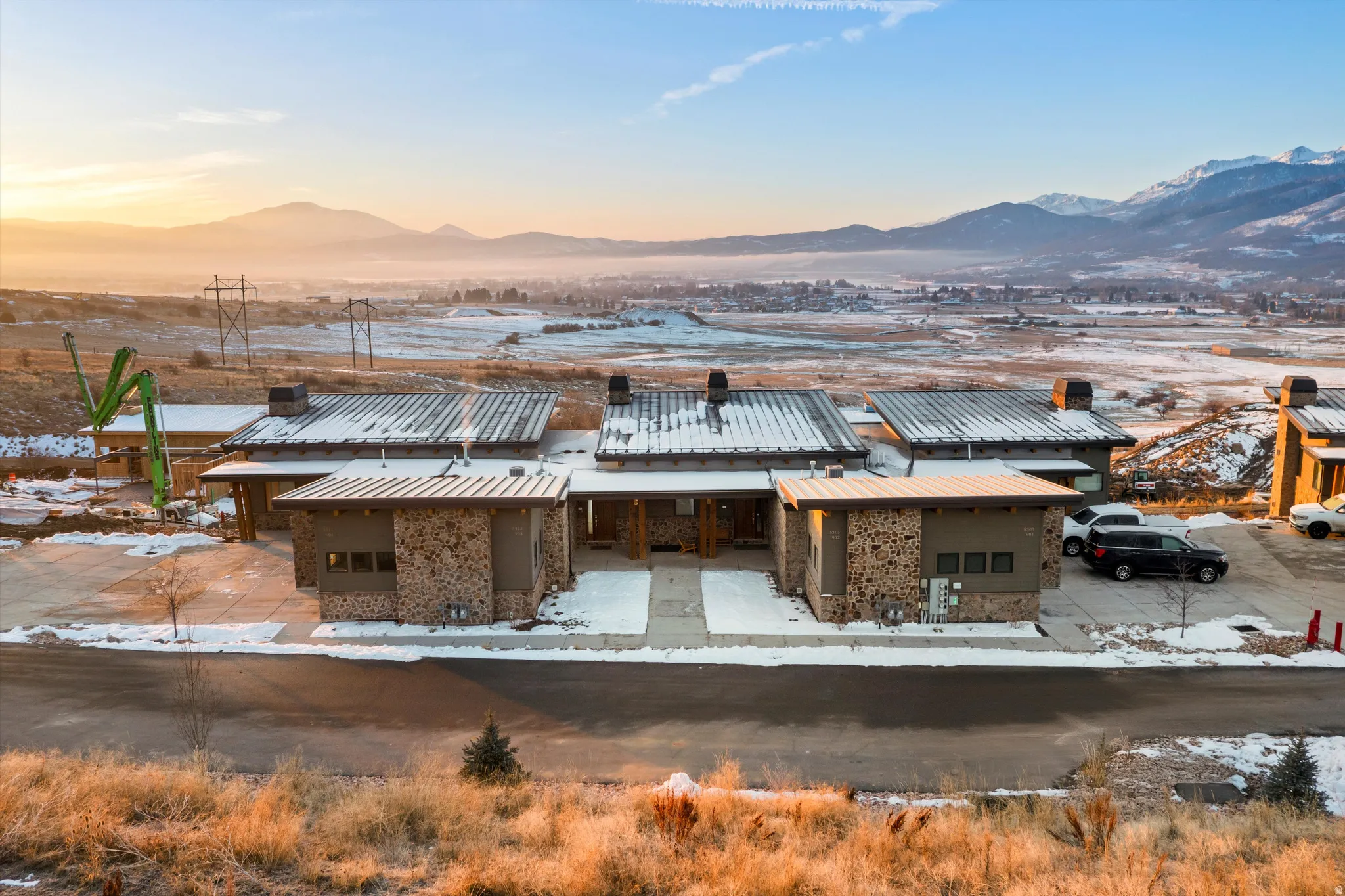 Snow covered house featuring a mountain view, brick siding, and a chimney
