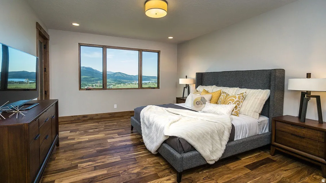 Bedroom featuring a mountain view, dark wood-style flooring, and recessed lighting