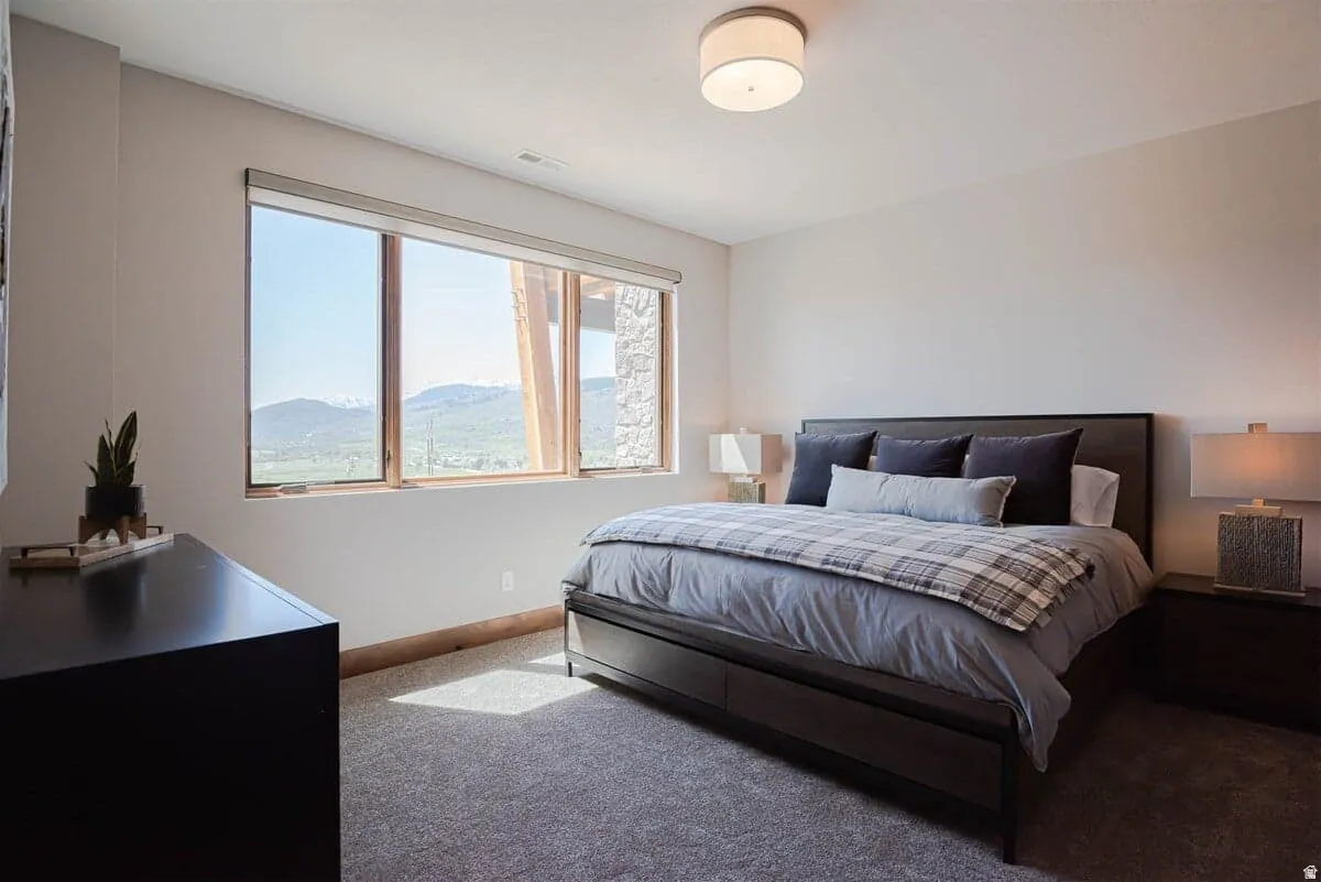 Carpeted bedroom featuring baseboards and a mountain view