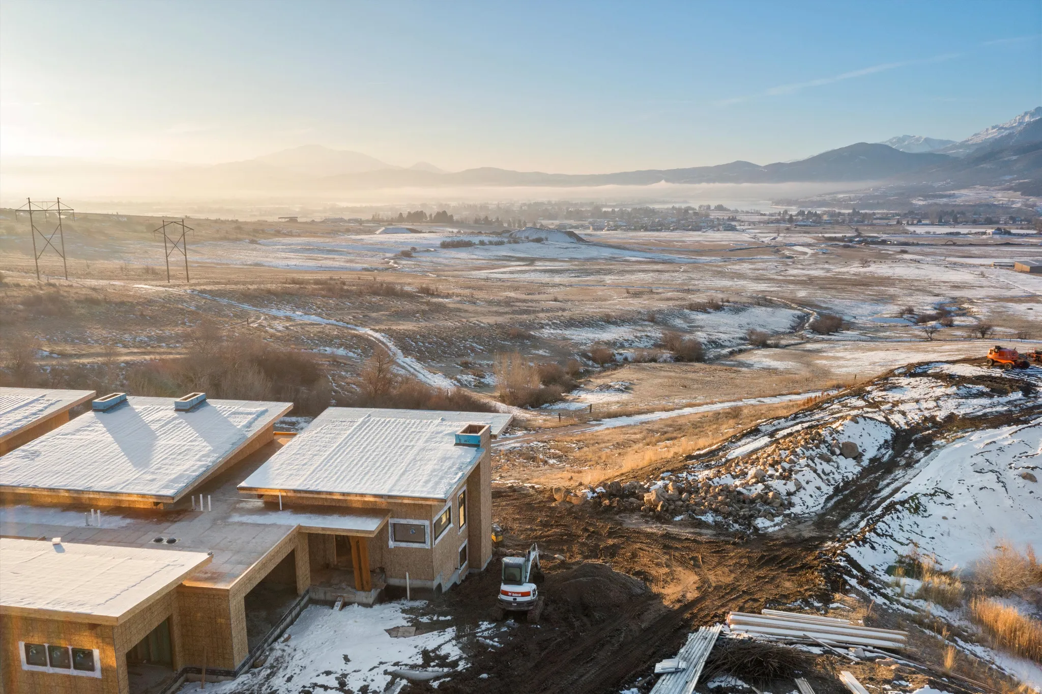 Snowy aerial view with a mountain view and a residential view