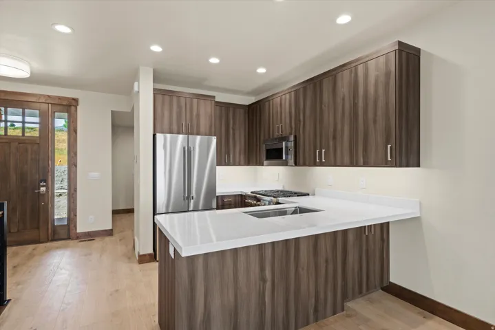 Modern kitchen featuring rich wood-finish cabinetry, white quartz countertops, and a generous island layout