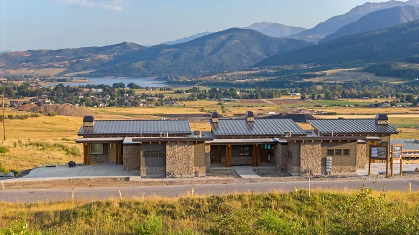 Modern stone and metal-clad residence featuring a clean-lined architectural design with multiple pitched metal roof sections