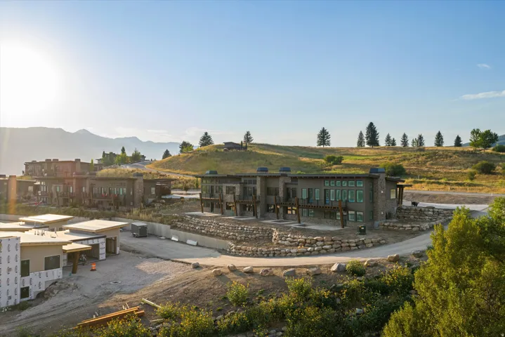 Modern residential complex featuring contemporary architecture with mixed material facades, including stone and wood-finish cladding