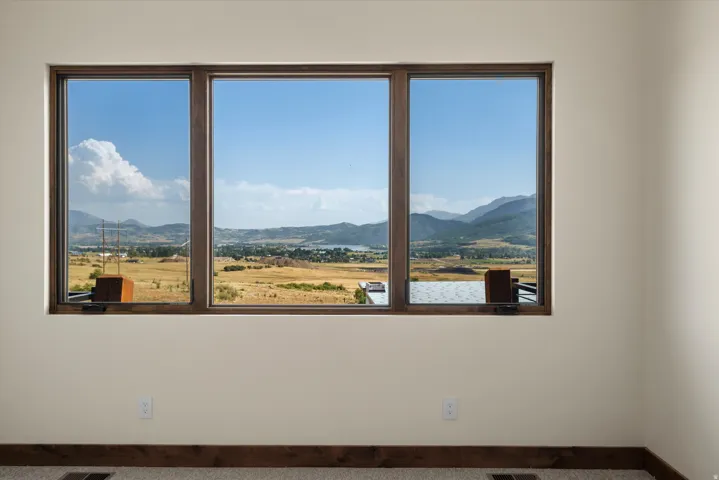 Triple window unit featuring dark wood-finish frames and a panoramic landscape