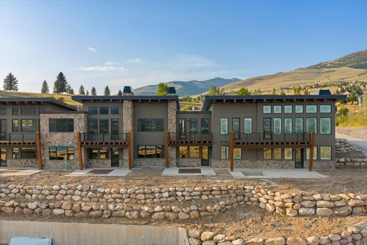 Modern multi-level residence featuring a stone and horizontal siding facade