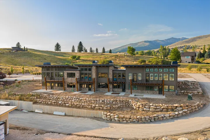 Contemporary multi-level exterior featuring stone accents and expansive window placements