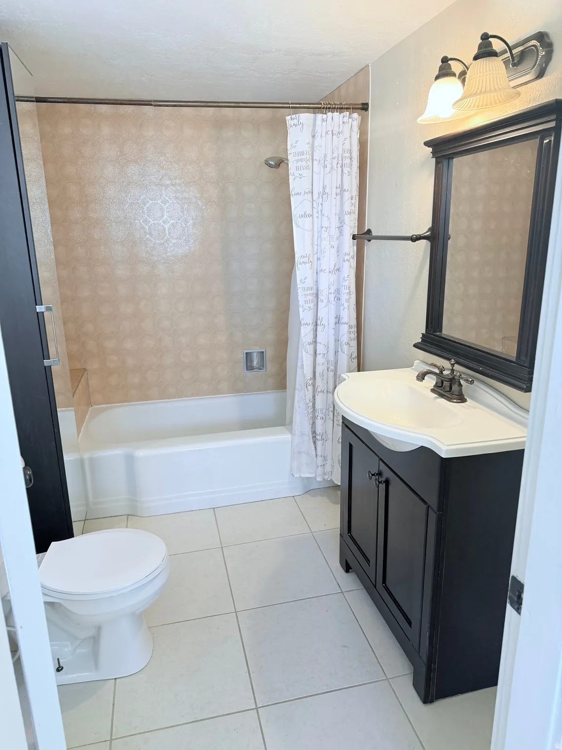 Bathroom featuring vanity, shower / bath combination with curtain, and light tile patterned floors