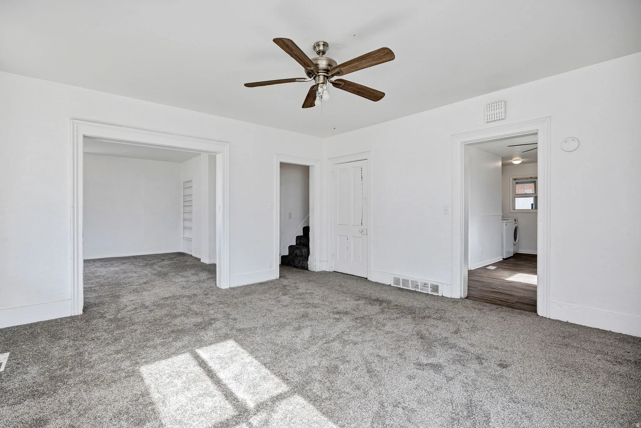 Unfurnished living room with ceiling fan and light carpet