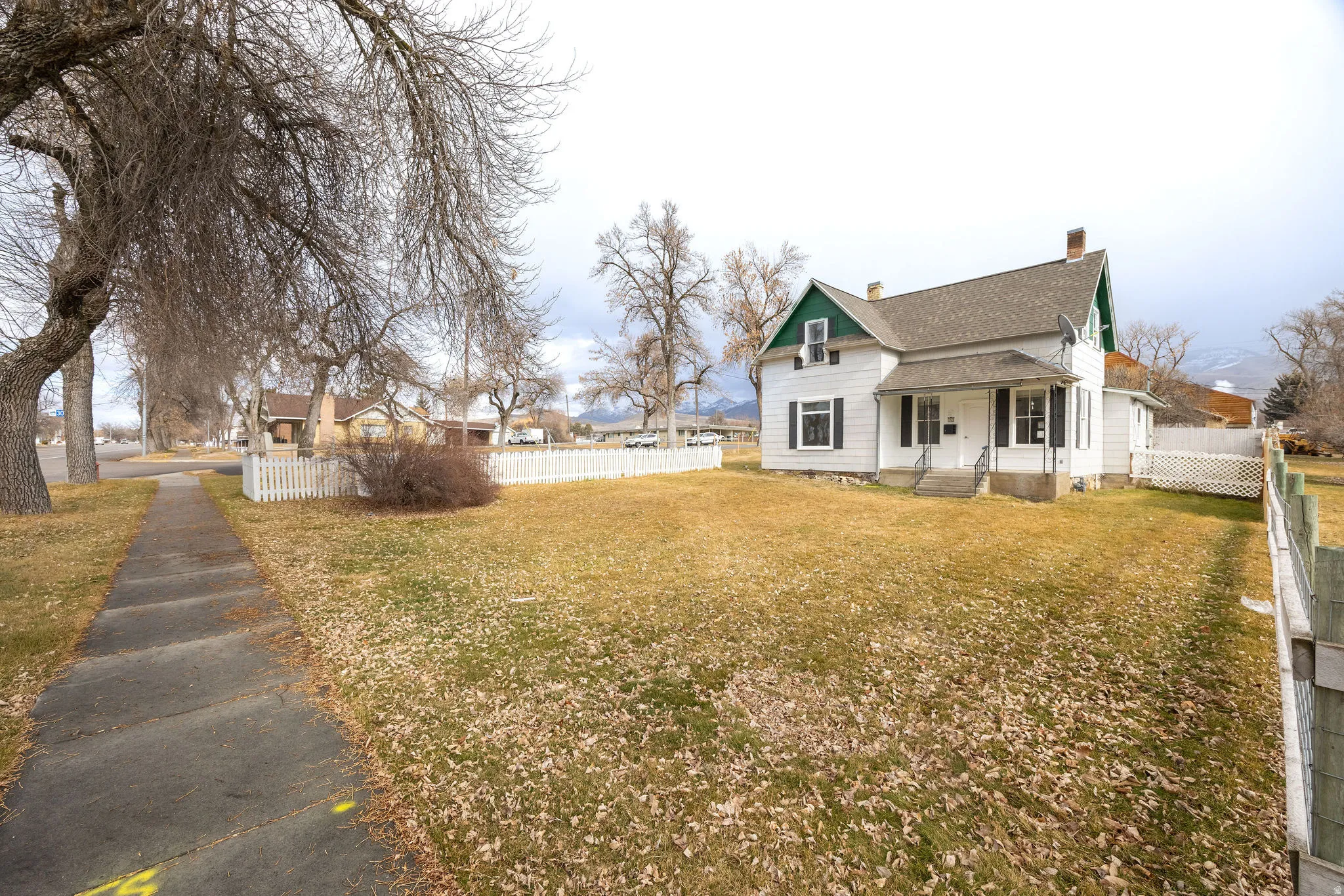 View of front of property featuring a chimney, a residential view, and a shingled roof
