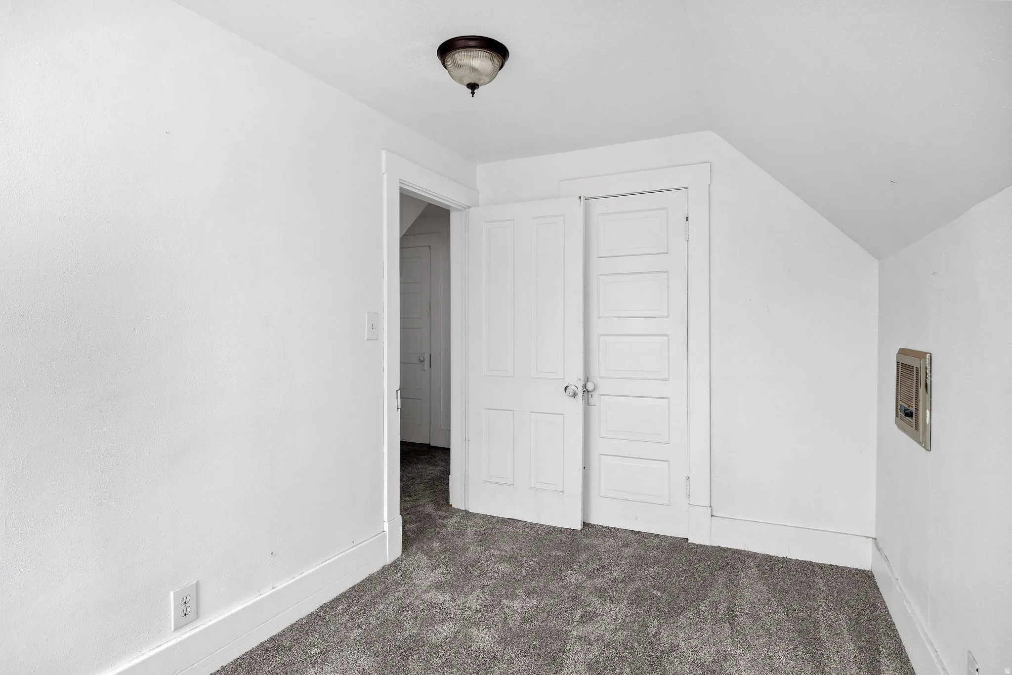 Additional living space featuring dark colored carpet and lofted ceiling