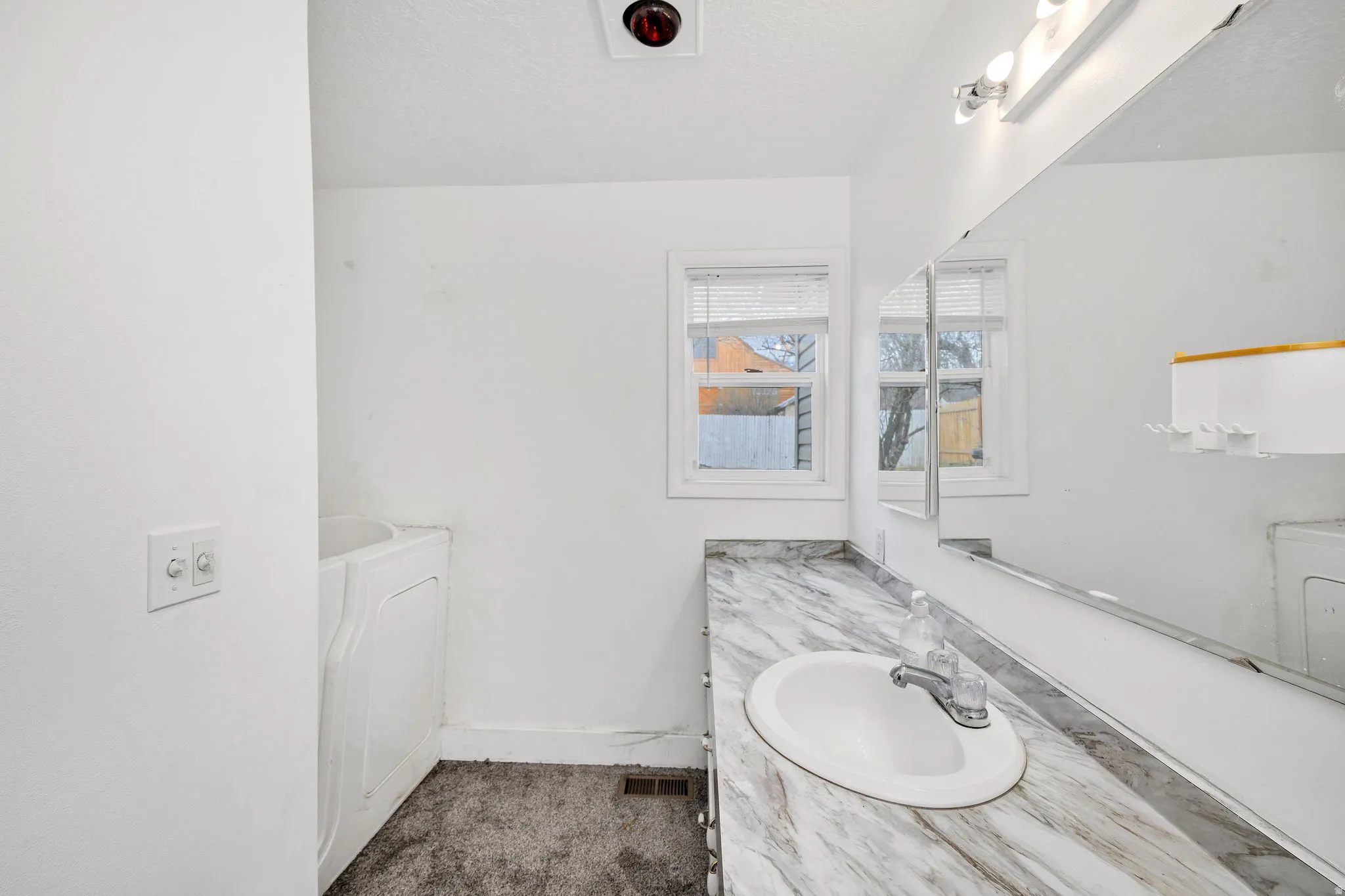 Full bathroom with vanity, a textured ceiling, a bathtub, and washer / dryer