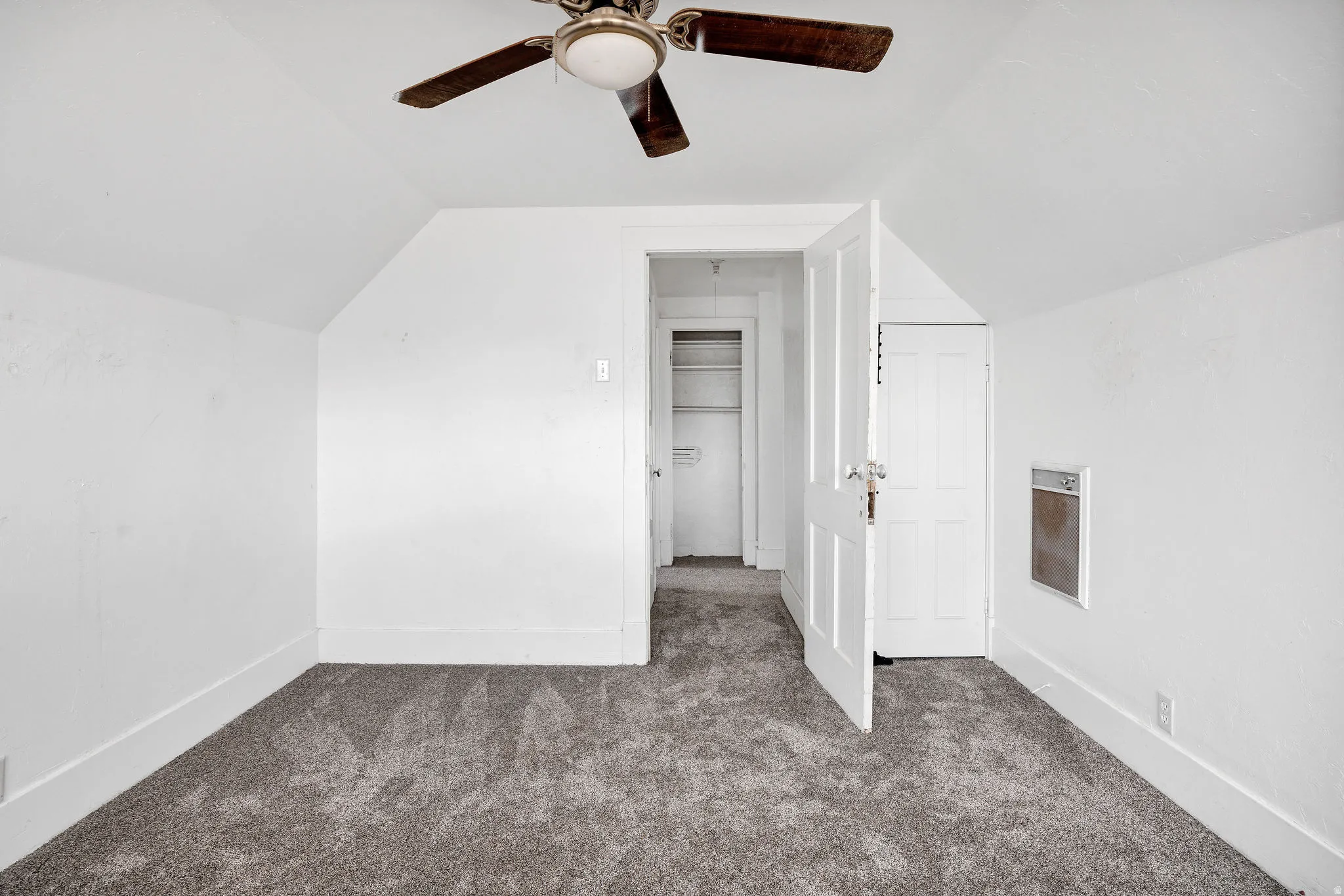 Additional living space featuring vaulted ceiling, carpet flooring, and a ceiling fan