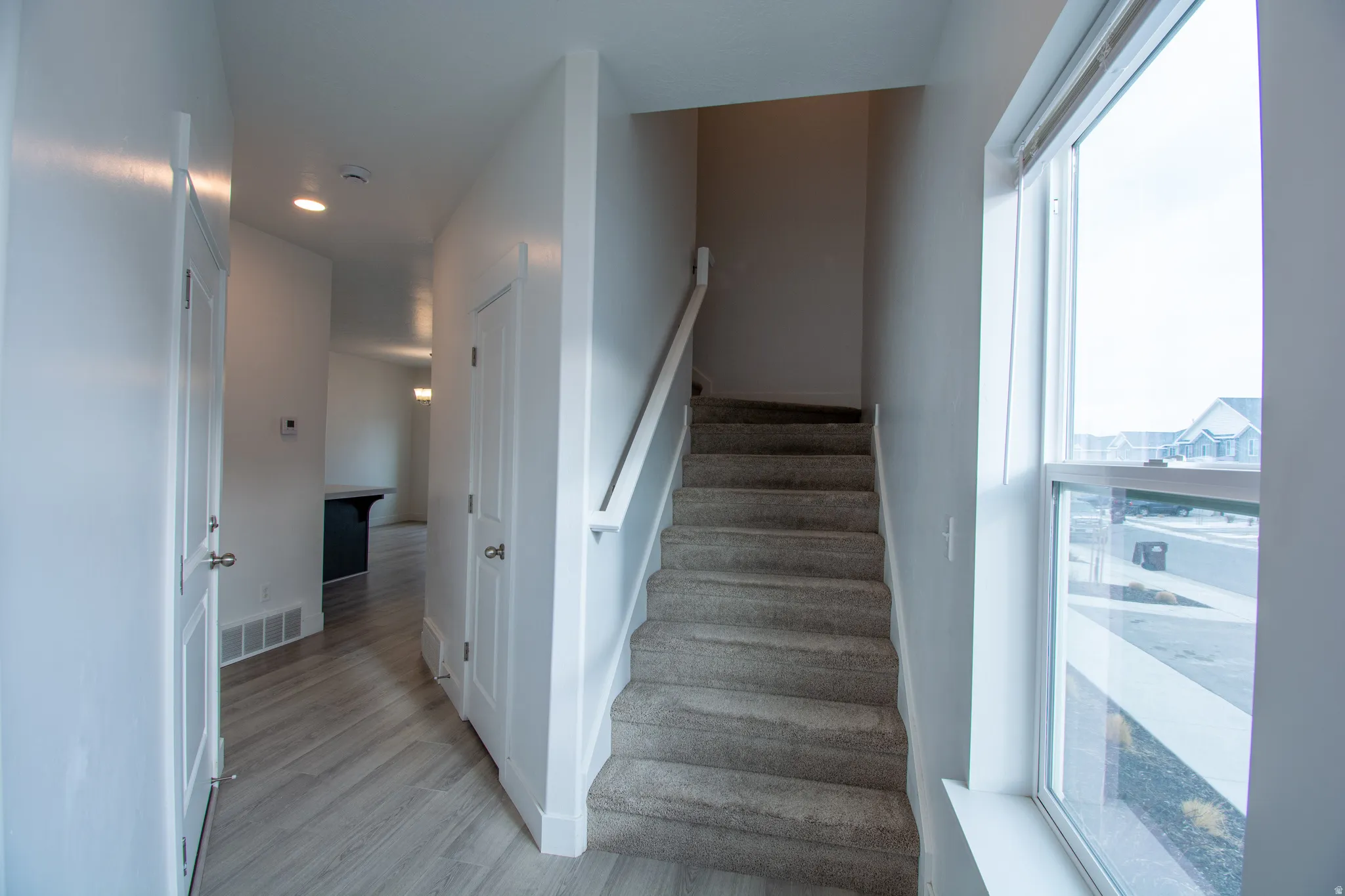 Stairway with wood finished floors and baseboards