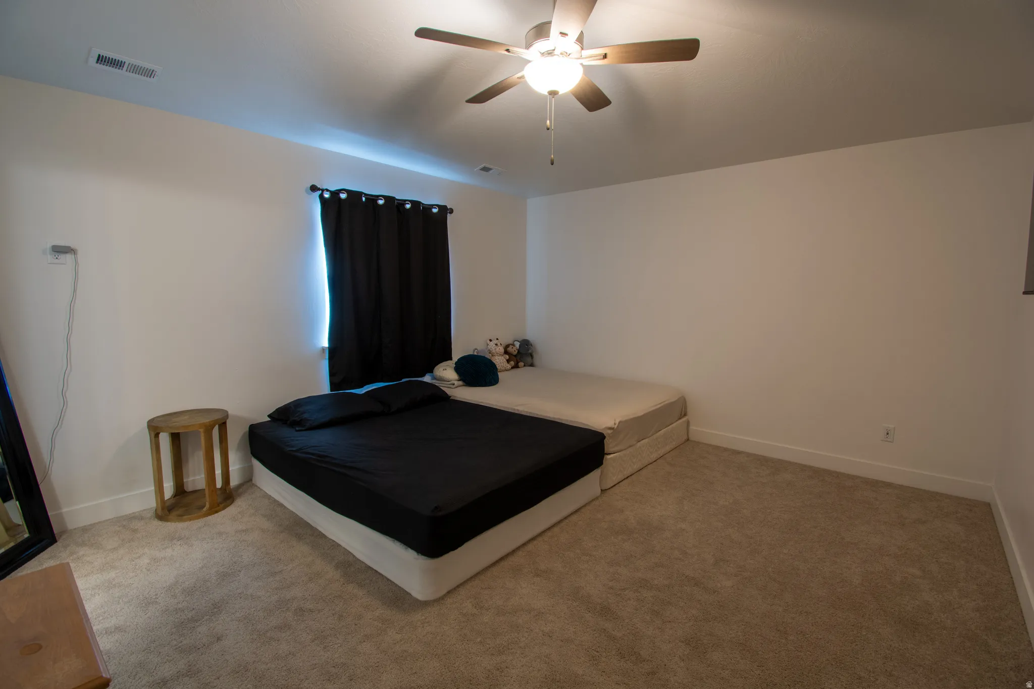Bedroom featuring ceiling fan and light carpet