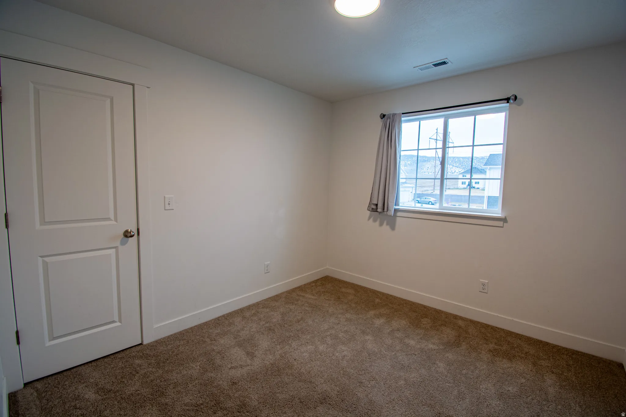 Empty room with carpet floors and baseboards