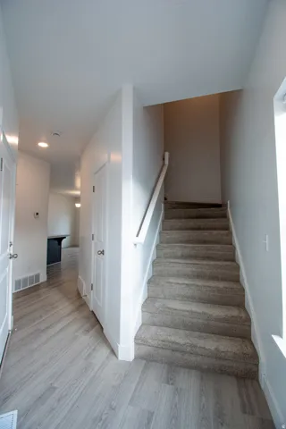 Stairs with wood finished floors and baseboards
