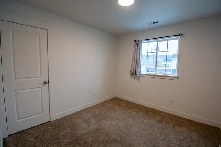 Empty room with carpet floors and baseboards