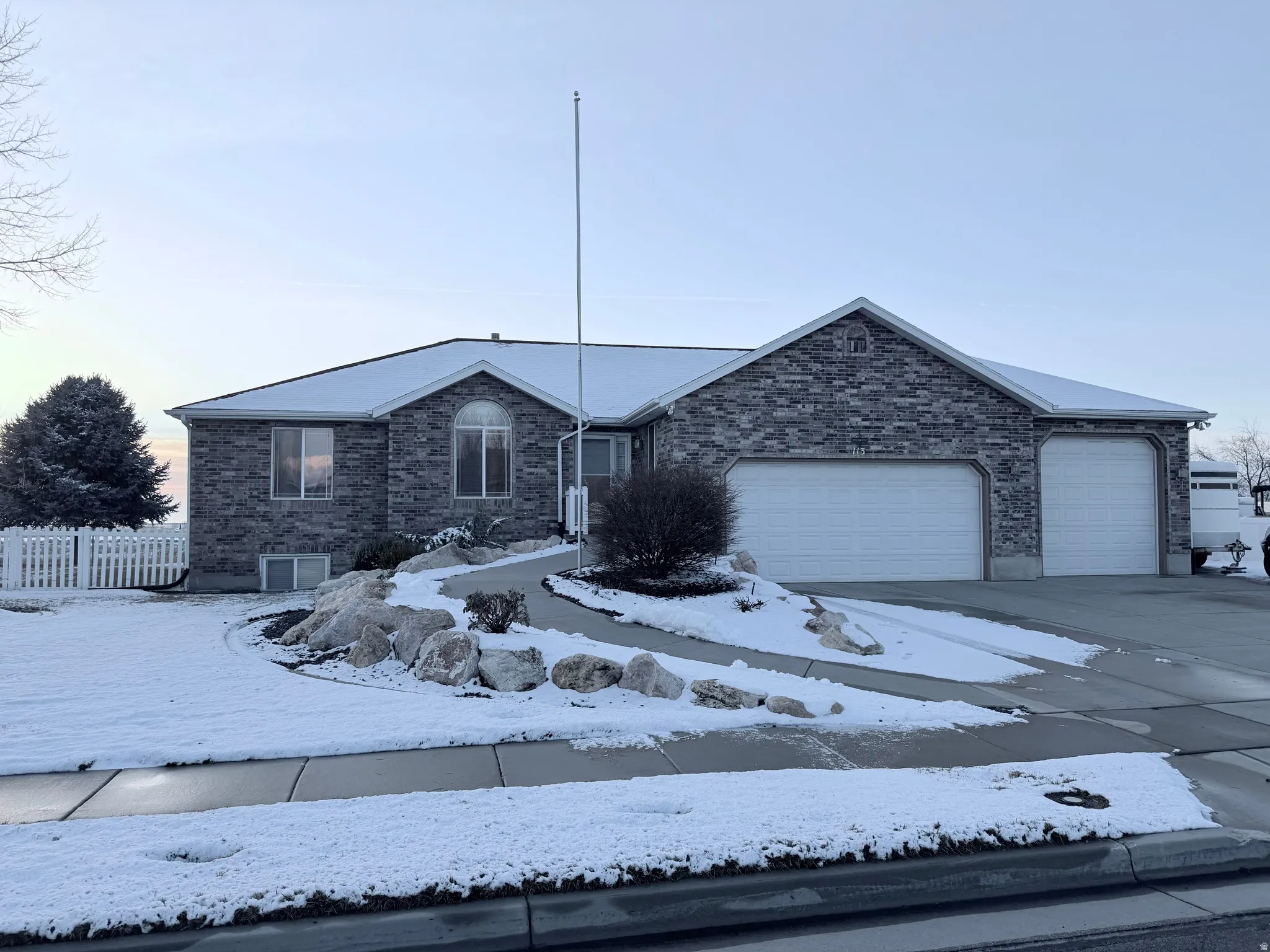 Ranch-style home featuring brick siding, an attached garage, and driveway