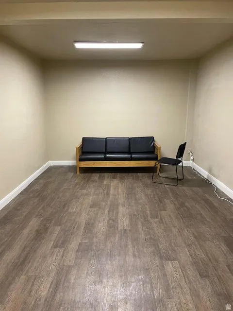 Living area featuring dark wood-style floors and baseboards