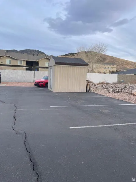 Uncovered parking lot featuring a shed