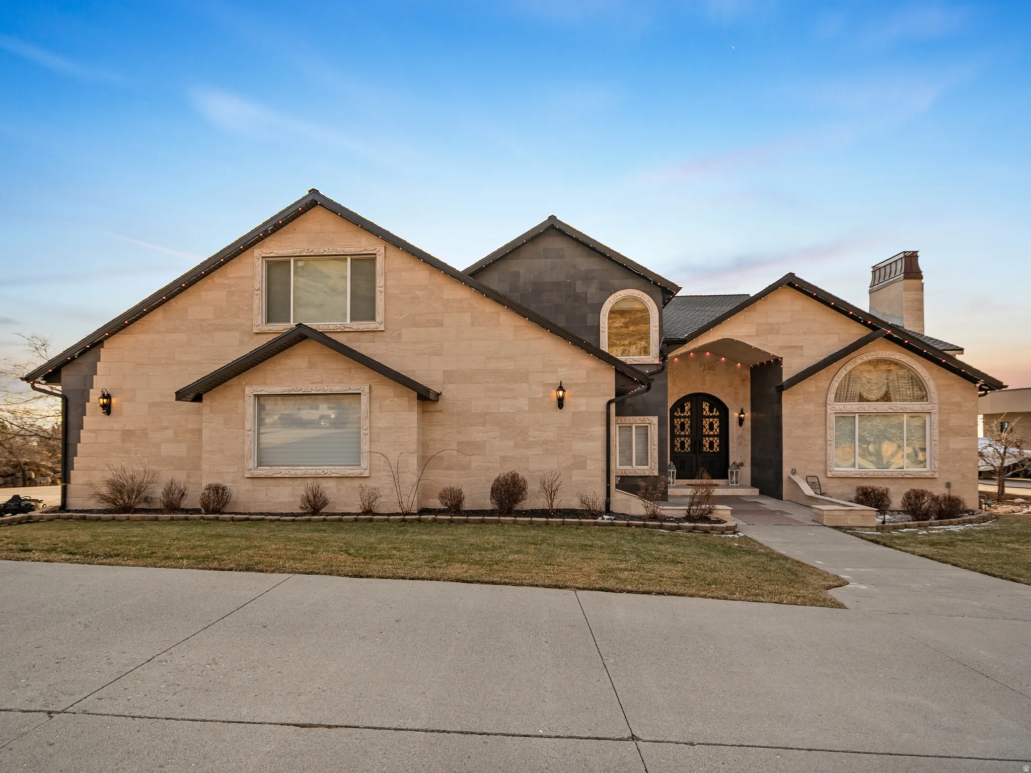 View of front of property with a chimney, a front lawn, stone siding, and french doors