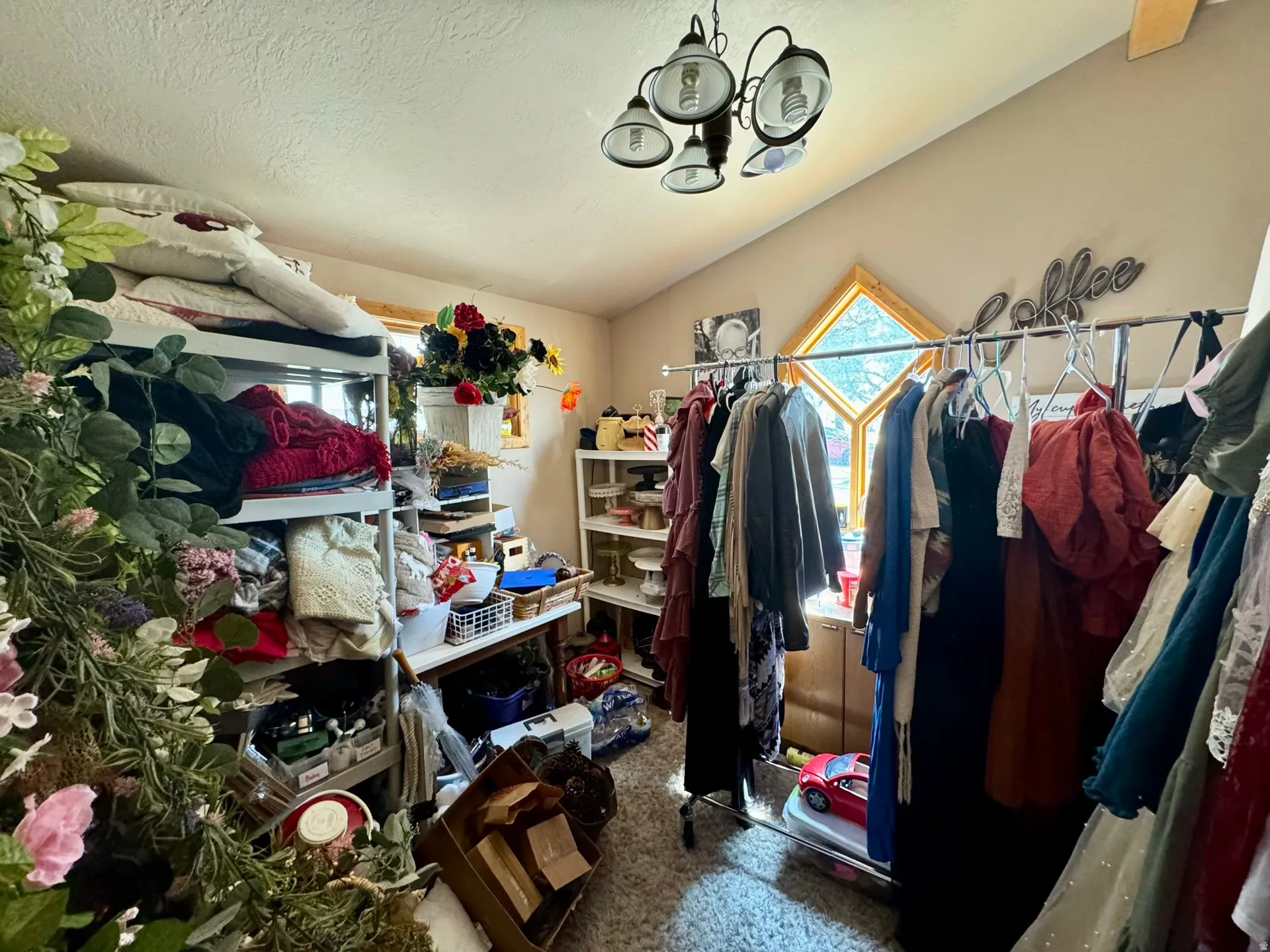 Spacious closet featuring a chandelier, carpet floors, and vaulted ceiling
