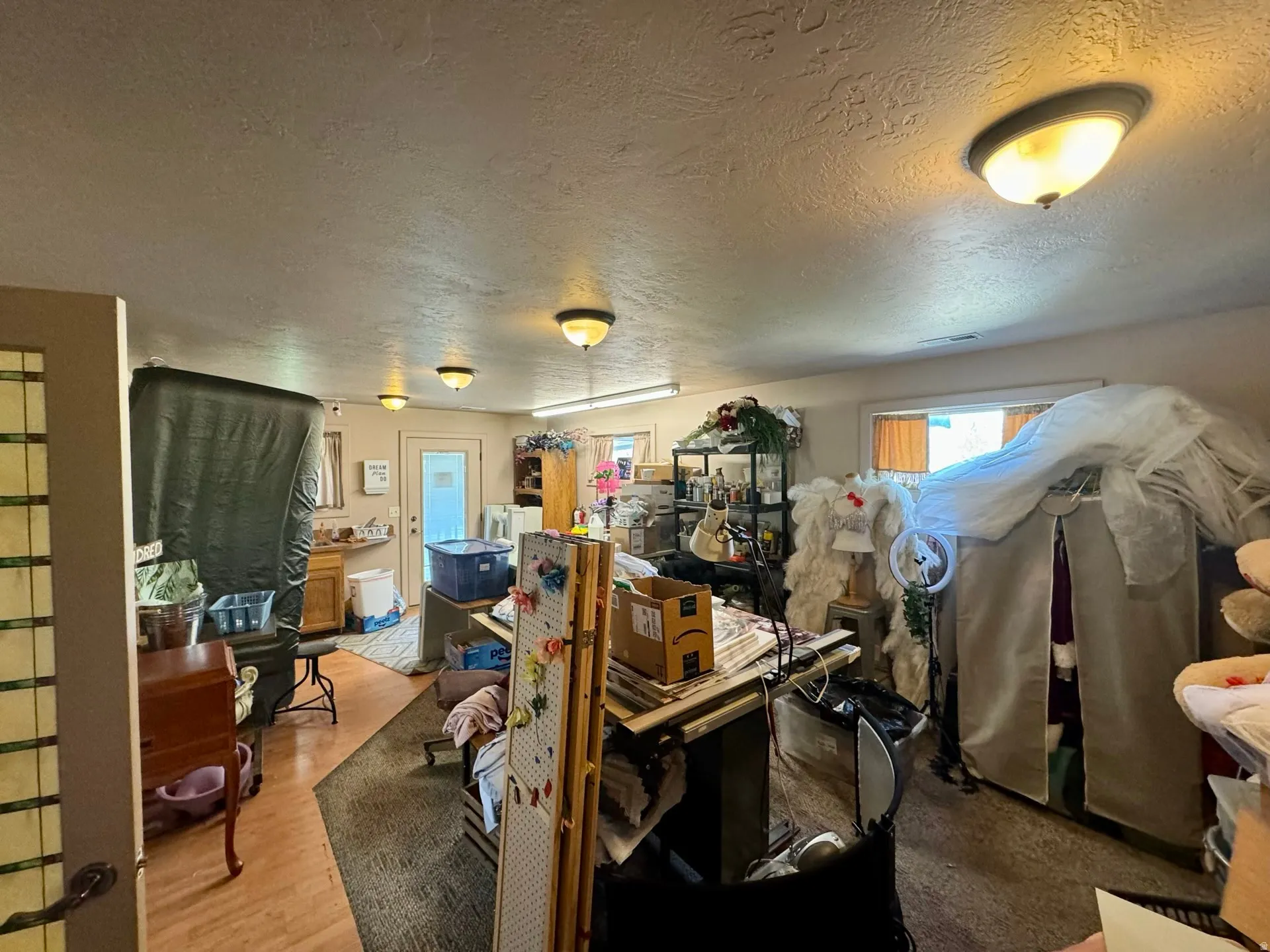 Misc room featuring a textured ceiling and light wood-type flooring