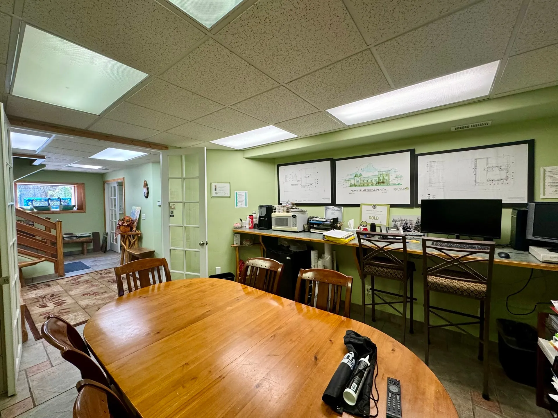Dining room with a drop ceiling, stone tile floors, and an office area