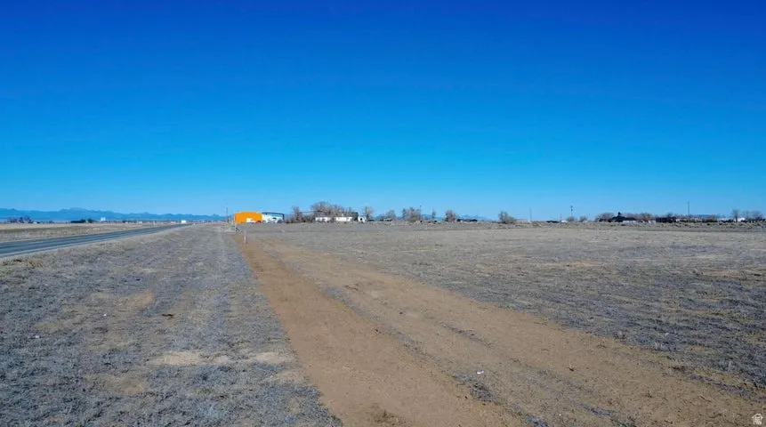 View of dirt / gravel road featuring a view of rural / pastoral area