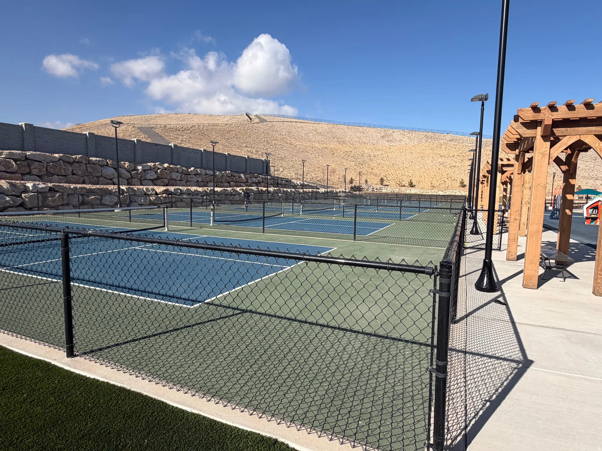 View of tennis court with a pergola