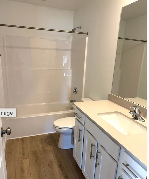 Full bathroom featuring dark wood finished floors, vanity, and shower / bath combination