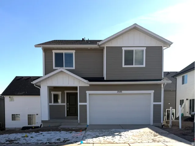 View of front of home featuring board and batten siding, a garage, covered porch, and concrete driveway