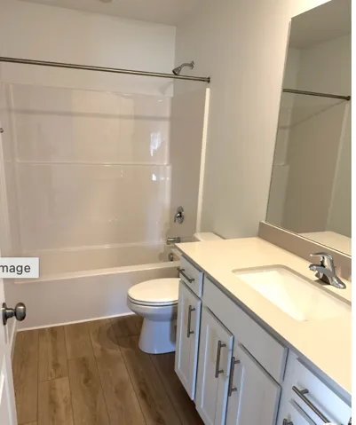Full bathroom featuring dark wood finished floors, vanity, and shower / bath combination