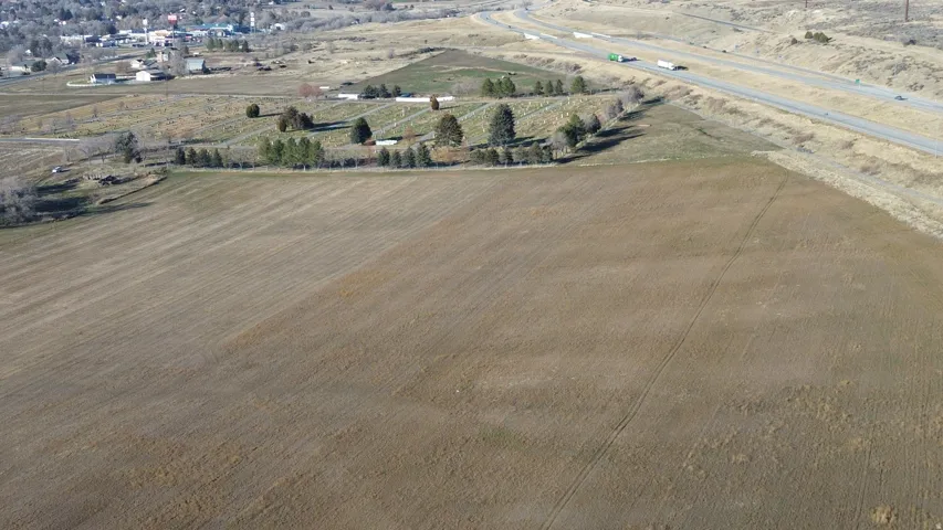 Aerial view of property and surrounding area featuring rural landscape and farmland