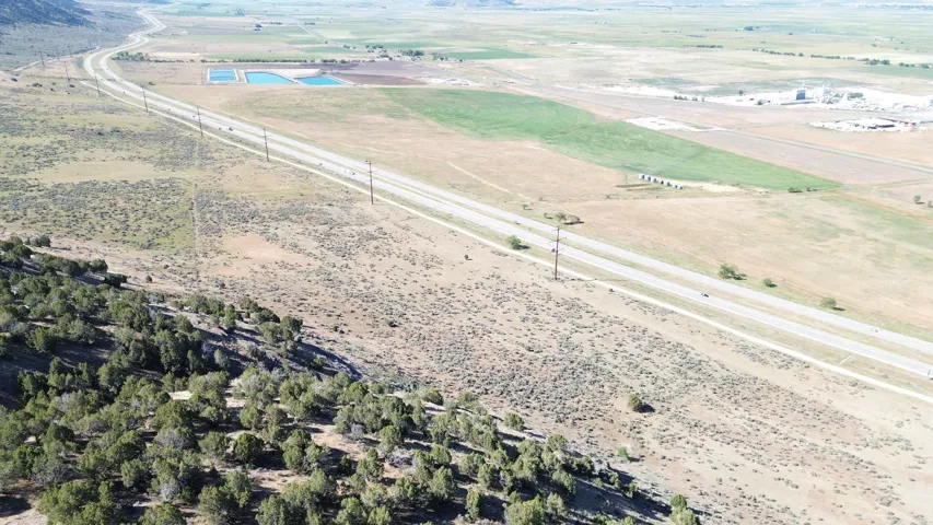 Expansive undeveloped land featuring natural terrain with scattered trees and vegetation