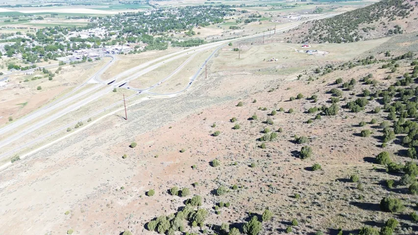 Expansive undeveloped terrain featuring diverse natural vegetation and a distant townsite