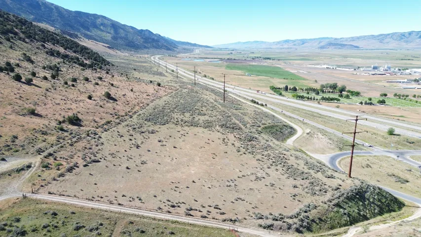 Expansive undeveloped land featuring natural foliage and a mountainous backdrop