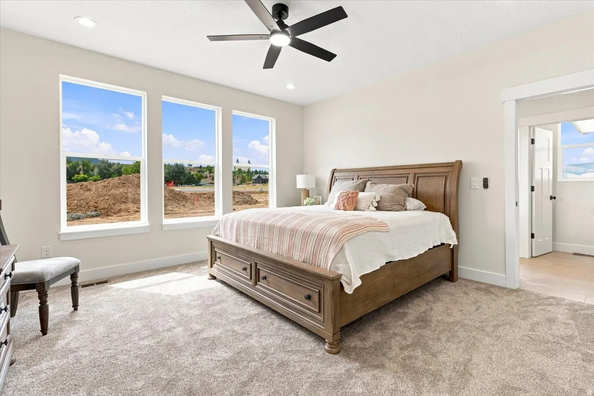 Recessed lighting, ceiling fan, plush carpet flooring, and multiple large windows