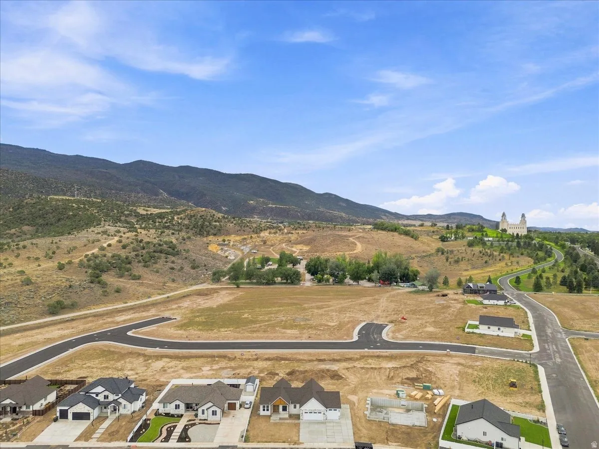 Developed residential area with mountain backdrop, paved roadways, and partially constructed residences