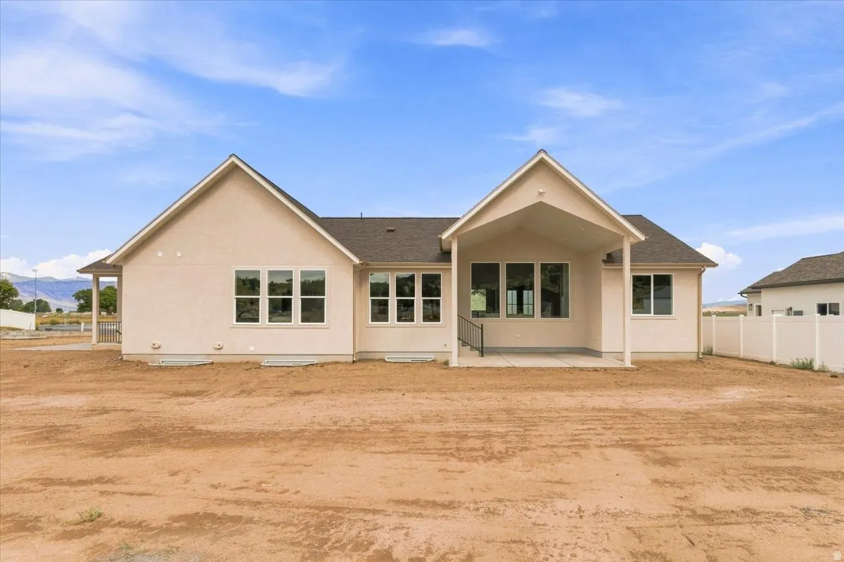 Stucco exterior with multiple gabled rooflines, covered patio space, and multiple windows