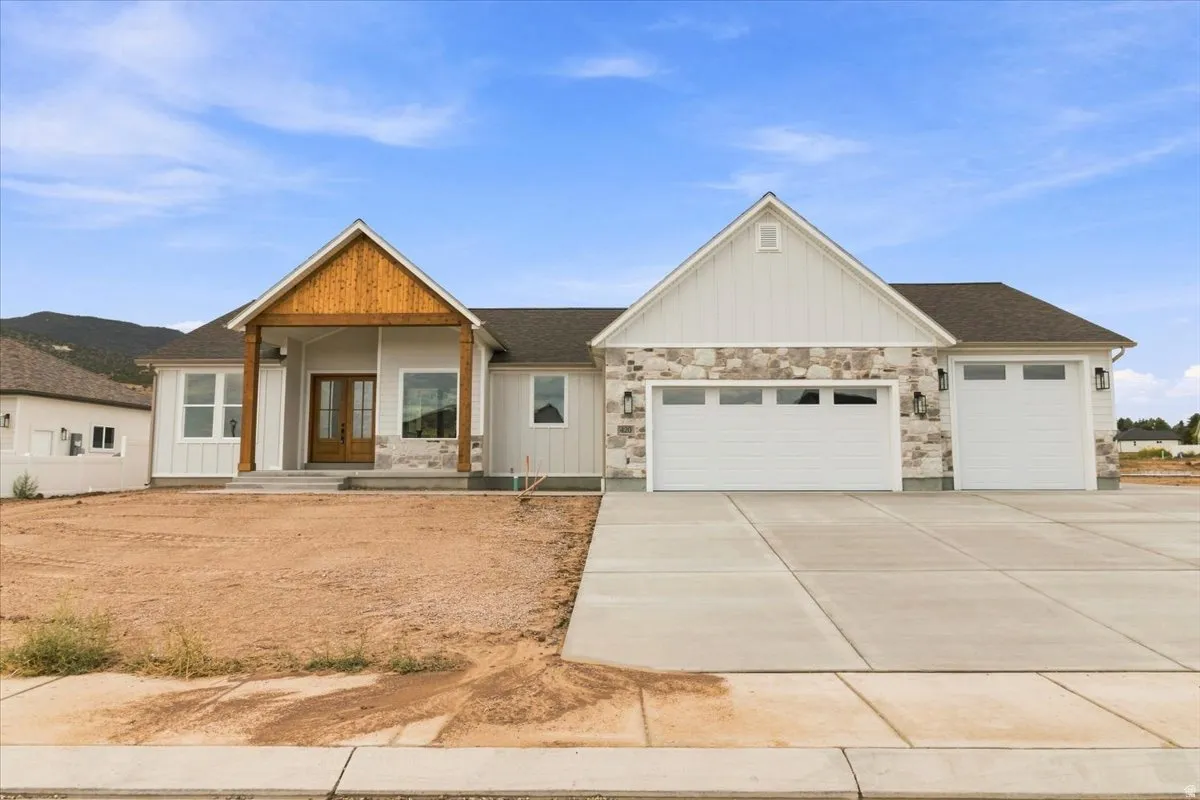 Modern farmhouse exterior with board and batten siding, stone accents, and a covered entry