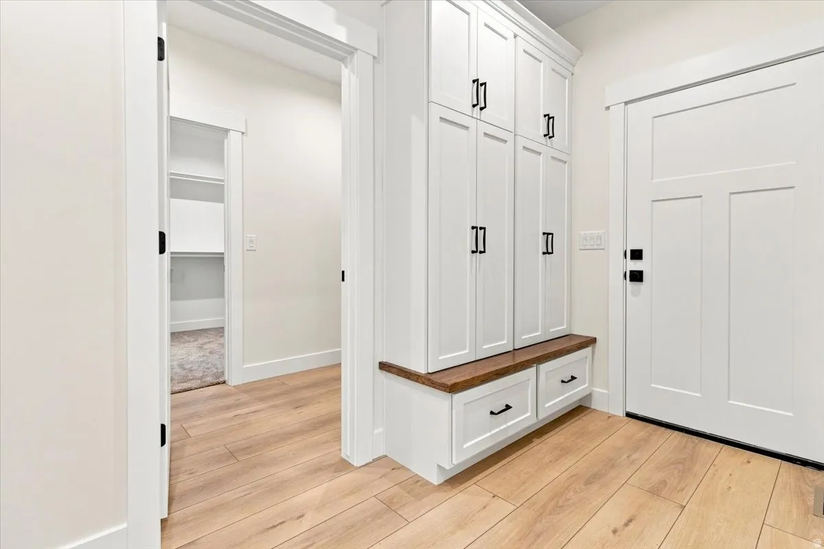 White built-in cabinetry with a wood-finish bench, two drawers, and matte black hardware