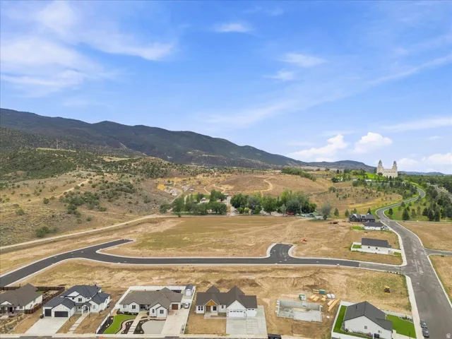 Developed residential area with mountain backdrop, paved roadways, and partially constructed residences