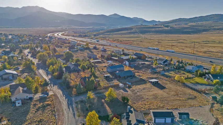 Aerial view of property and surrounding area with nearby suburban area and a mountain backdrop