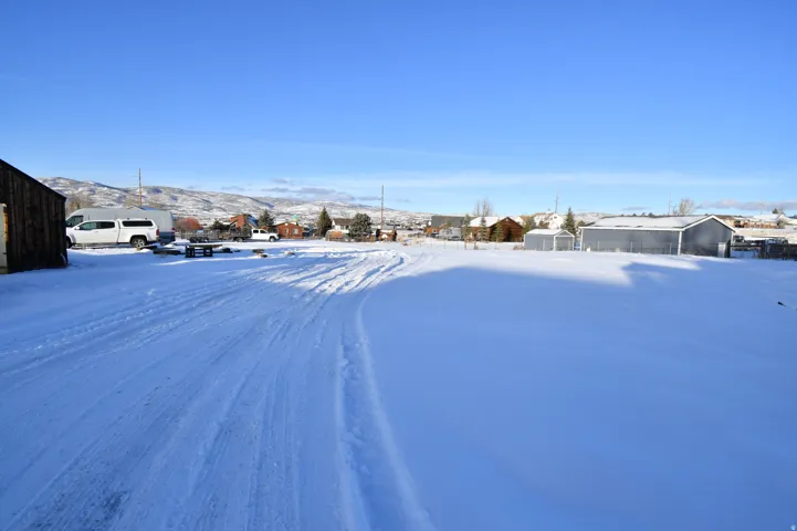 Yard layered in snow featuring a mountain view