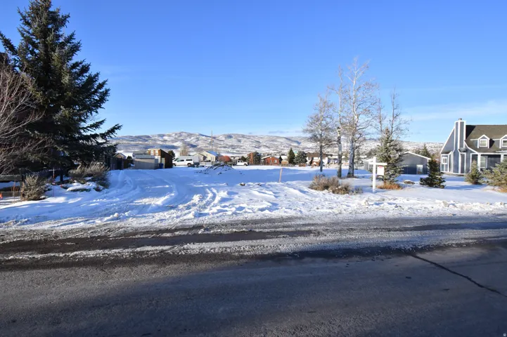 Yard covered in snow with a residential view and a mountain view
