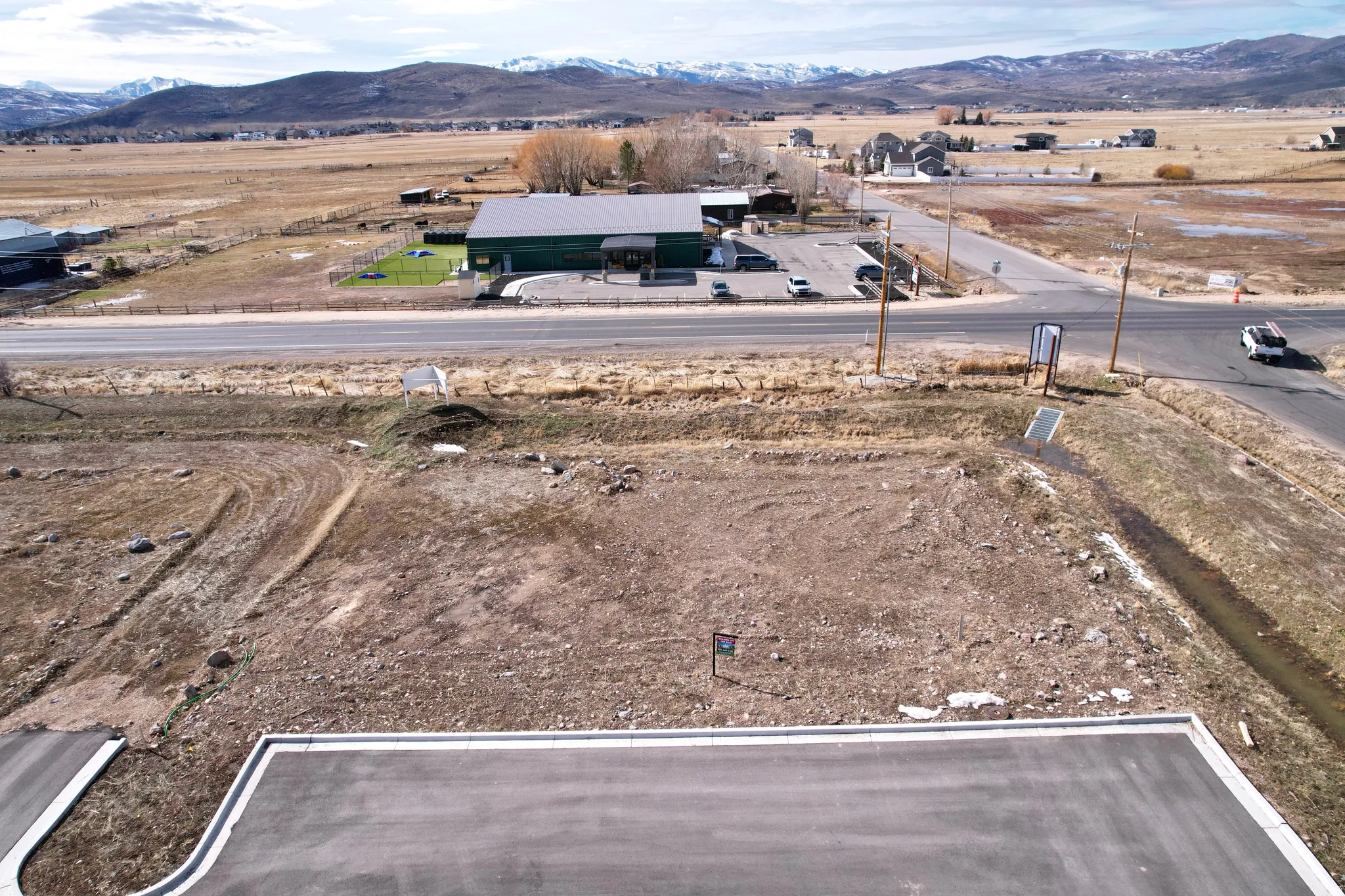Aerial view of property and surrounding area featuring a mountainous background