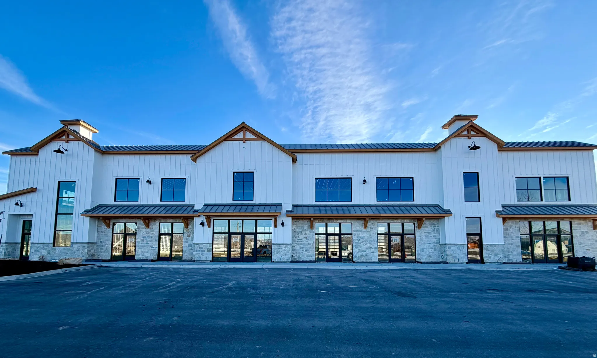Back of property featuring stone siding, a standing seam roof, and a metal roof