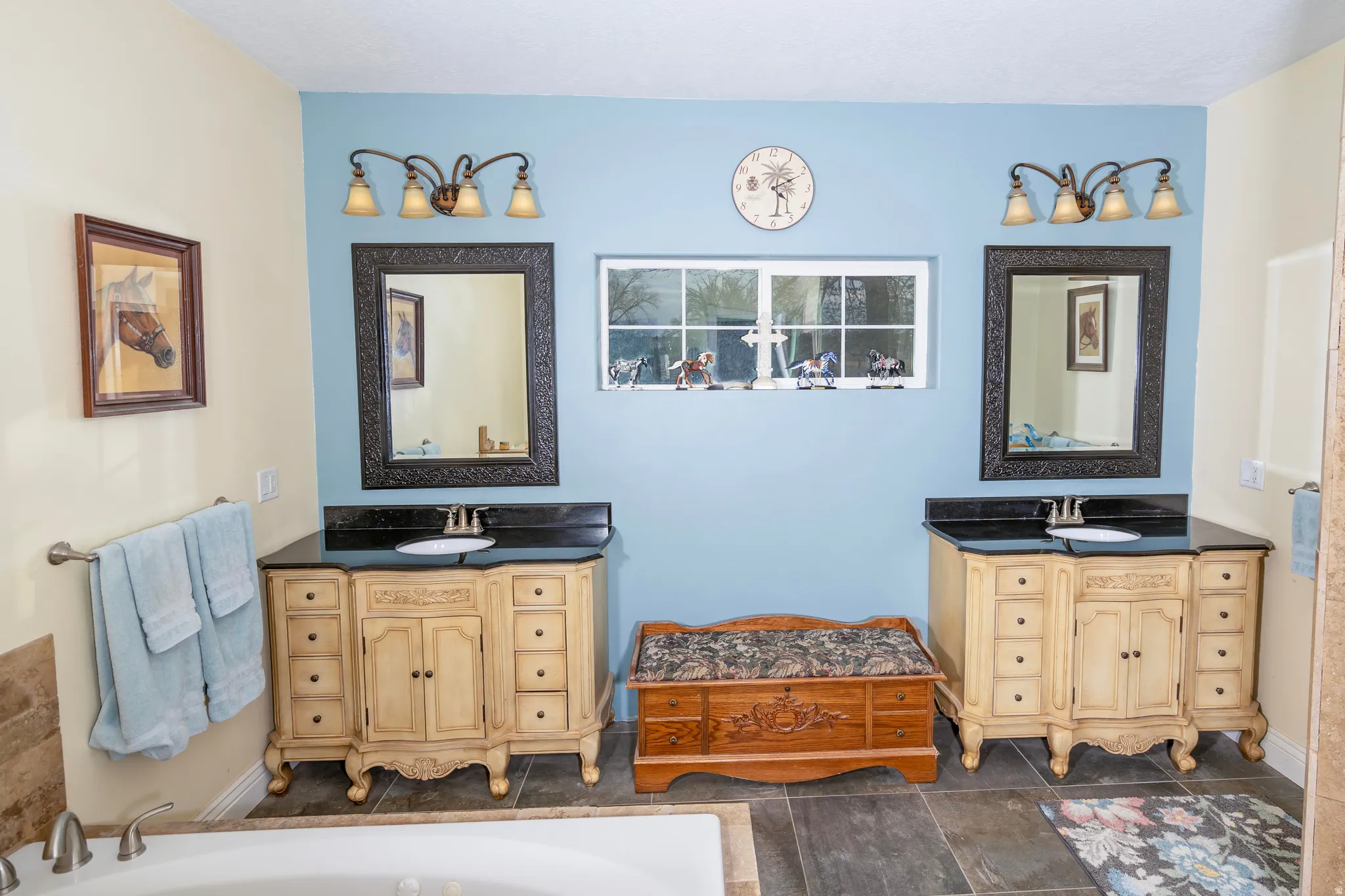 Full bath featuring two vanities and a tub to relax in